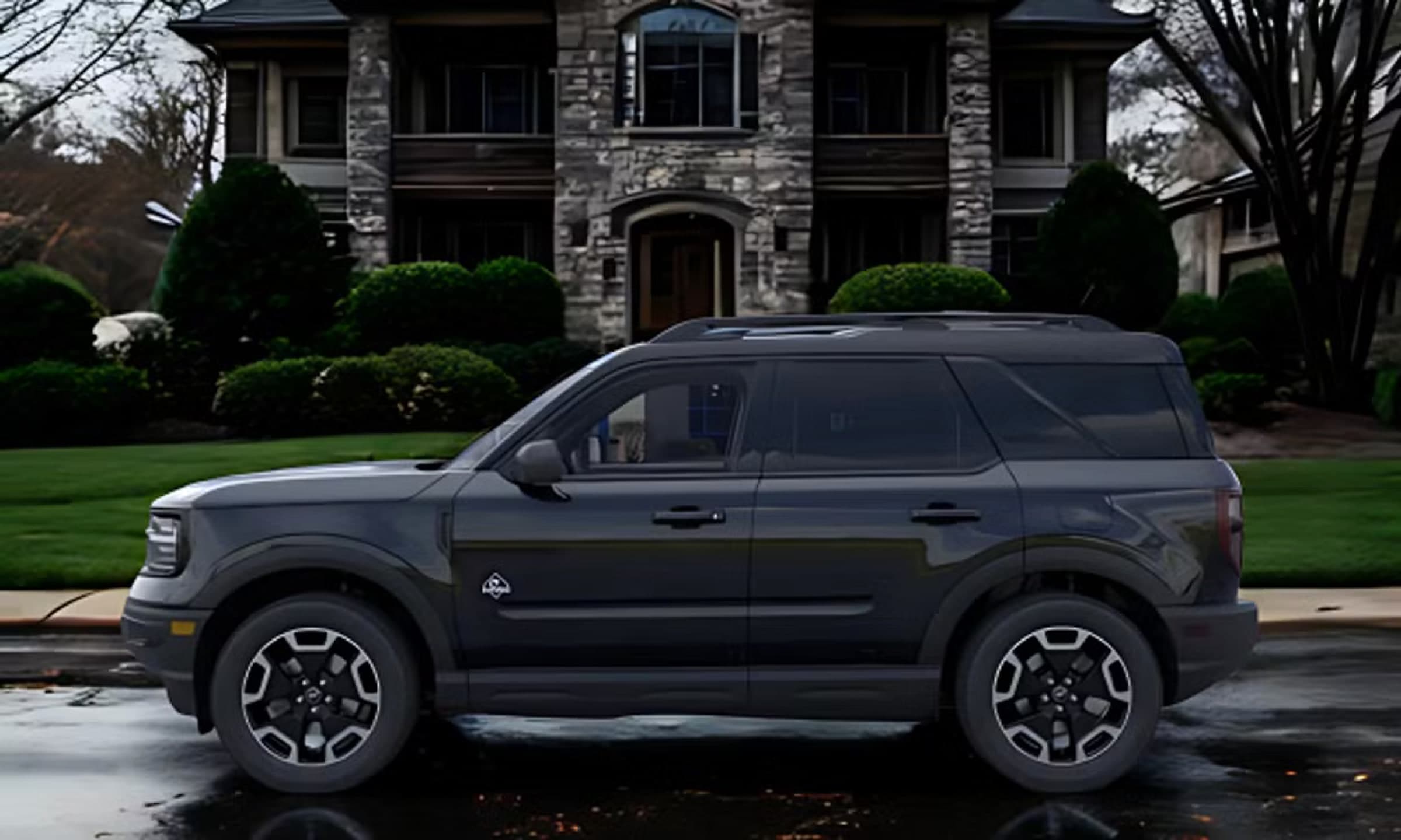 Rentalp's 2024 Ford Bronco Sport, side profile in front of a stone-clad home